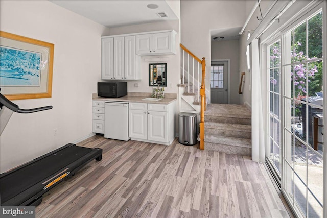 kitchen with white cabinetry, light hardwood / wood-style flooring, sink, and dishwasher