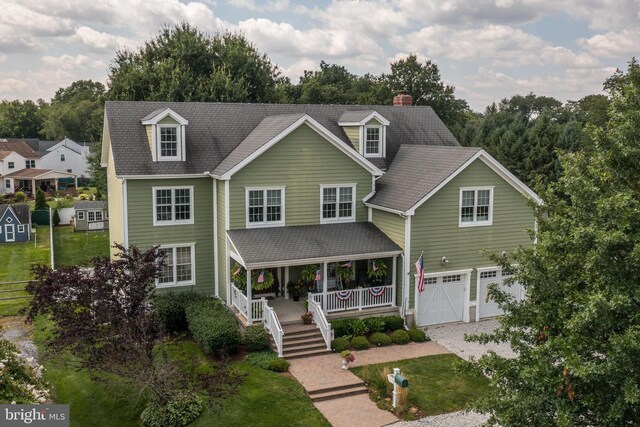 view of front of property with a garage, a front lawn, and a porch