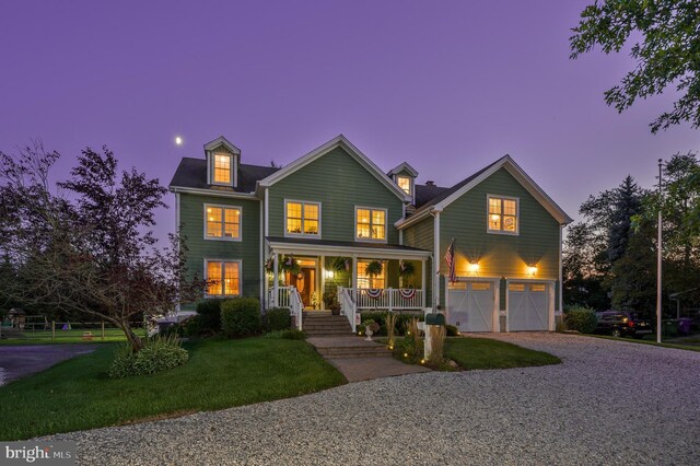 view of front of house with a garage, a front yard, and a porch