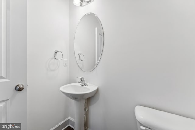 bathroom featuring toilet and baseboards