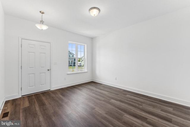 entrance foyer with dark wood-style floors, visible vents, and baseboards