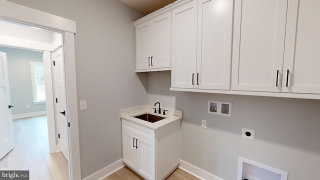 clothes washing area with sink, cabinets, hookup for a washing machine, light hardwood / wood-style floors, and electric dryer hookup