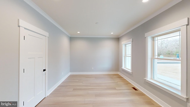 spare room with crown molding and light hardwood / wood-style floors