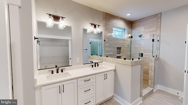 bathroom with a tile shower, wood-type flooring, and vanity