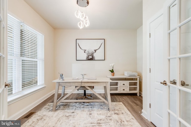 office with an inviting chandelier, hardwood / wood-style flooring, and a wealth of natural light