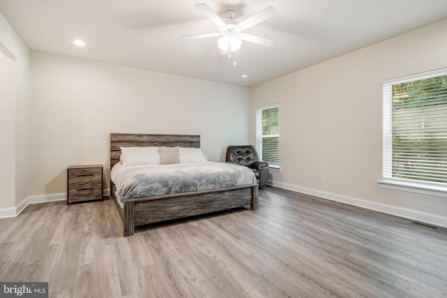 bedroom with multiple windows, light wood-type flooring, and ceiling fan