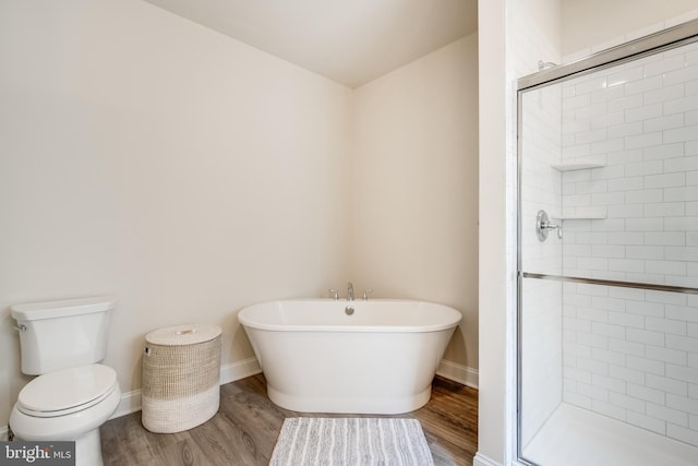 bathroom with hardwood / wood-style flooring, a shower with shower door, and toilet