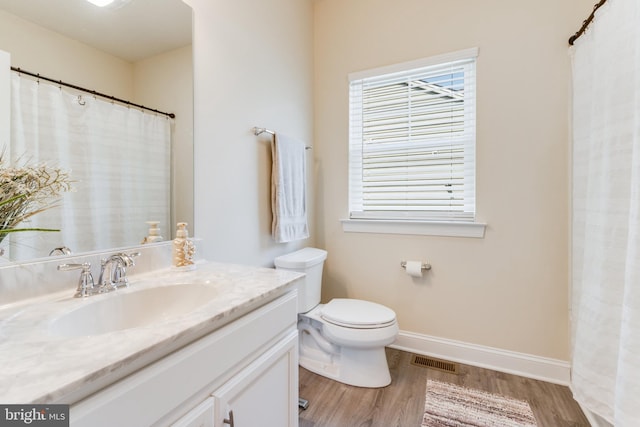 bathroom featuring wood-type flooring, toilet, and vanity