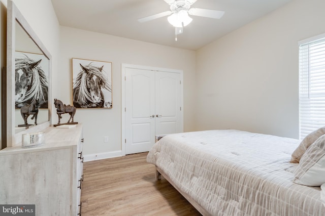 bedroom with light hardwood / wood-style floors, a closet, and ceiling fan