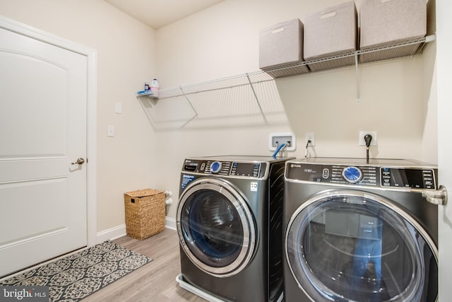 laundry room featuring separate washer and dryer and light hardwood / wood-style floors