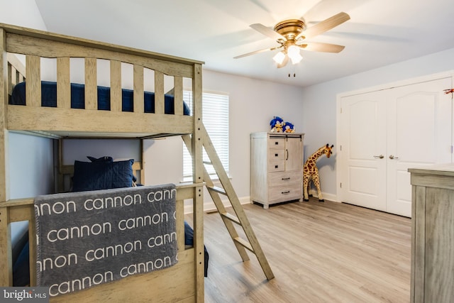 bedroom with light hardwood / wood-style flooring, a closet, and ceiling fan