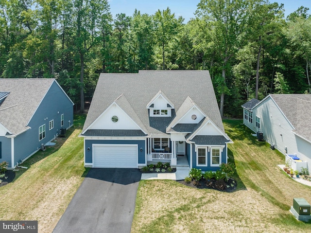 view of front facade featuring a porch, a garage, central AC, and a front yard