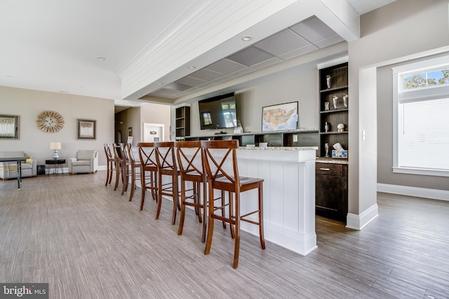 kitchen featuring dark brown cabinetry, a kitchen breakfast bar, and hardwood / wood-style floors