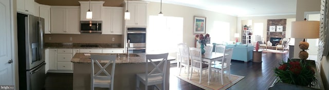 kitchen featuring decorative light fixtures, dark hardwood / wood-style flooring, white cabinets, and stainless steel appliances