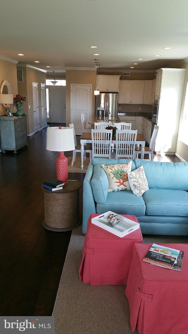 living room with wood-type flooring and crown molding