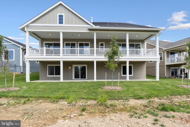 back of house with a yard, board and batten siding, and a patio