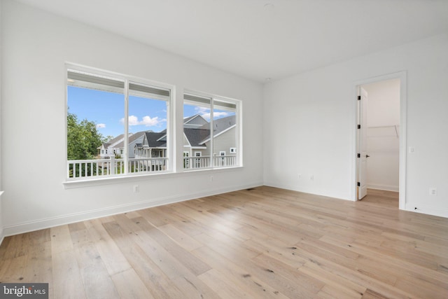 unfurnished room with a healthy amount of sunlight and light wood-type flooring