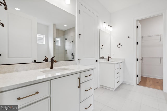 bathroom featuring vanity, a shower with shower door, and tile patterned flooring