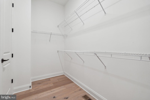 walk in closet with hardwood / wood-style floors