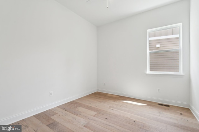 unfurnished room with visible vents, ceiling fan, light wood-style flooring, and baseboards