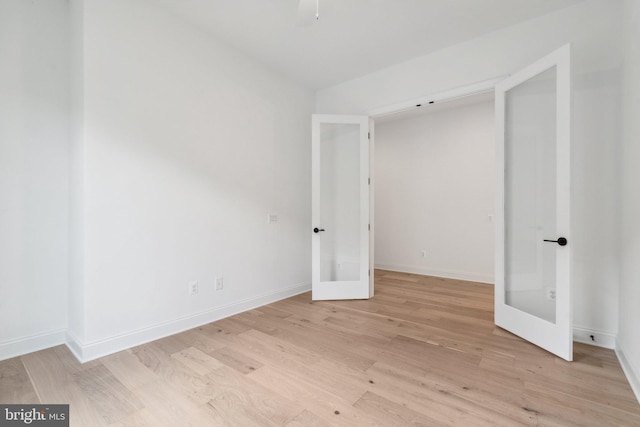 unfurnished bedroom with light wood-style flooring, baseboards, and french doors