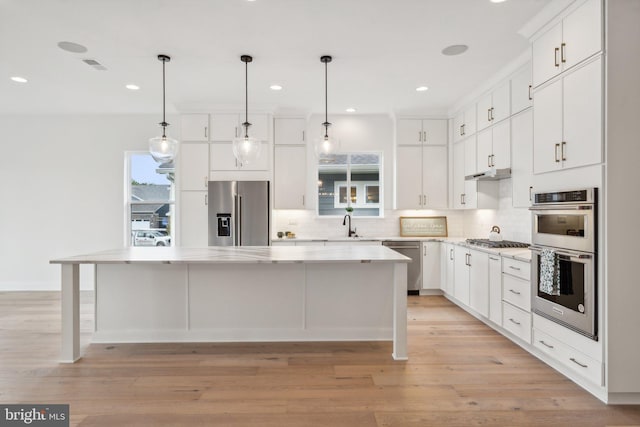 kitchen featuring stainless steel appliances, a center island, and white cabinets