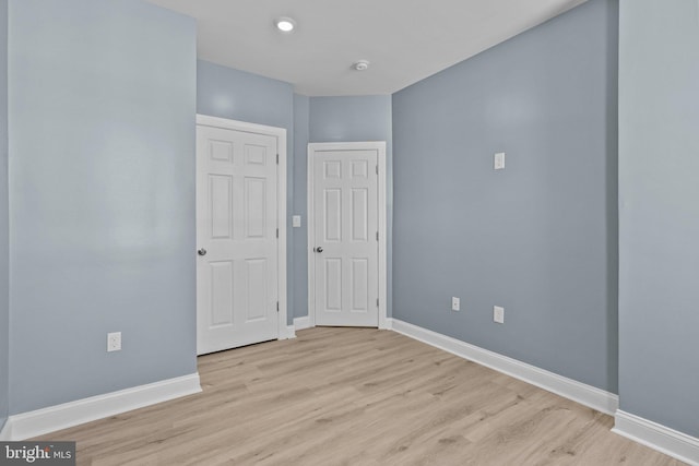 empty room with light wood-style flooring and baseboards