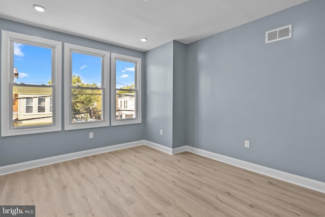 spare room with light wood-type flooring, visible vents, baseboards, and recessed lighting