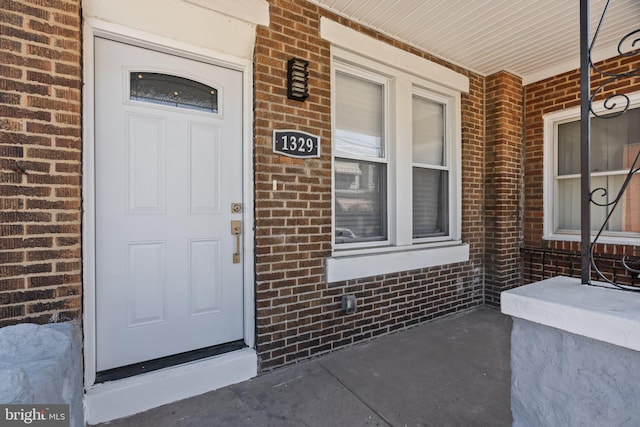 entrance to property featuring brick siding