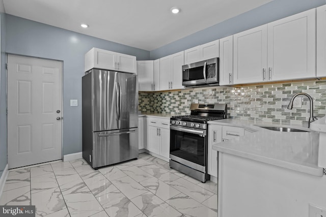 kitchen featuring stainless steel appliances, marble finish floor, white cabinetry, and a sink