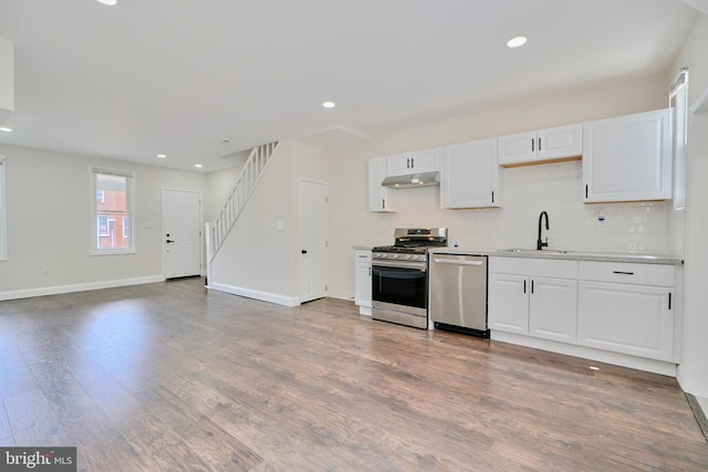 kitchen with sink, wood-type flooring, stainless steel appliances, and white cabinetry