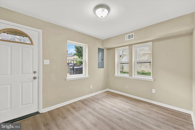 foyer entrance with electric panel and light hardwood / wood-style floors