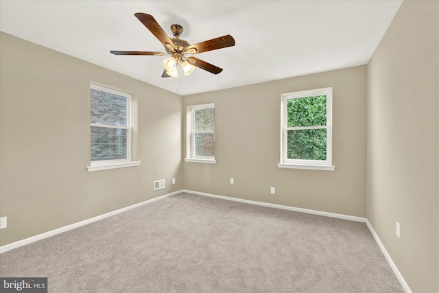 carpeted spare room with ceiling fan