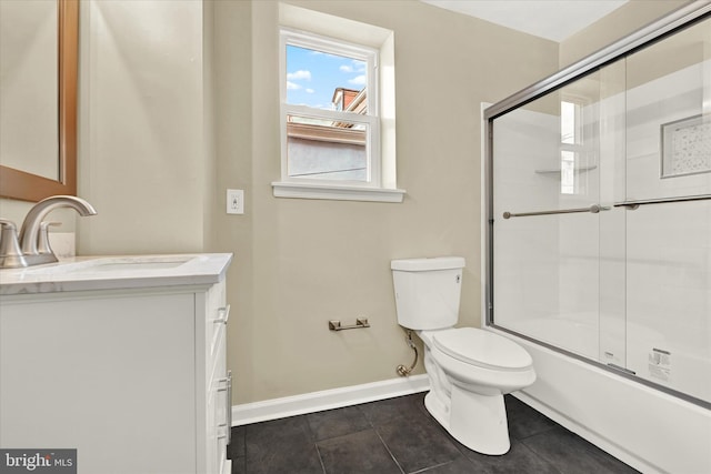 full bathroom with toilet, tile patterned floors, vanity, and bath / shower combo with glass door