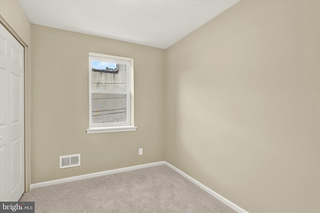 unfurnished bedroom featuring a closet and light carpet