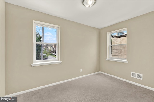 unfurnished room with plenty of natural light and carpet