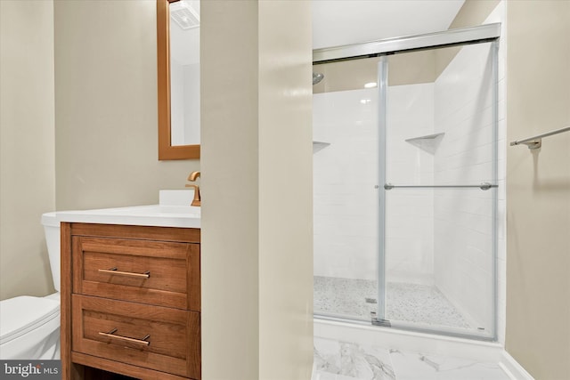 bathroom featuring vanity, a shower with door, and toilet