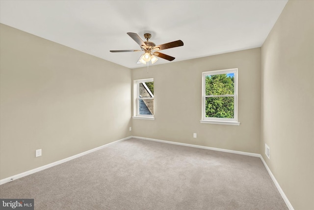 empty room with carpet floors, a wealth of natural light, and ceiling fan