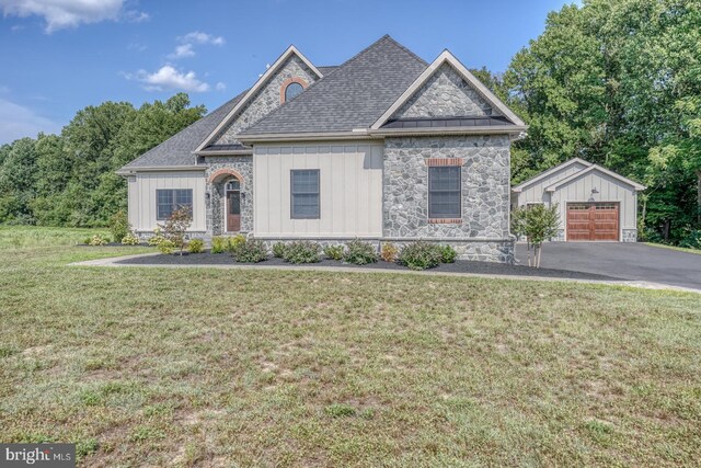 view of front of property featuring an outbuilding, a garage, and a front lawn