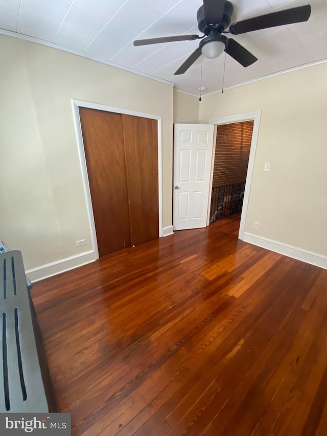 unfurnished bedroom featuring a closet, wood-type flooring, and ceiling fan