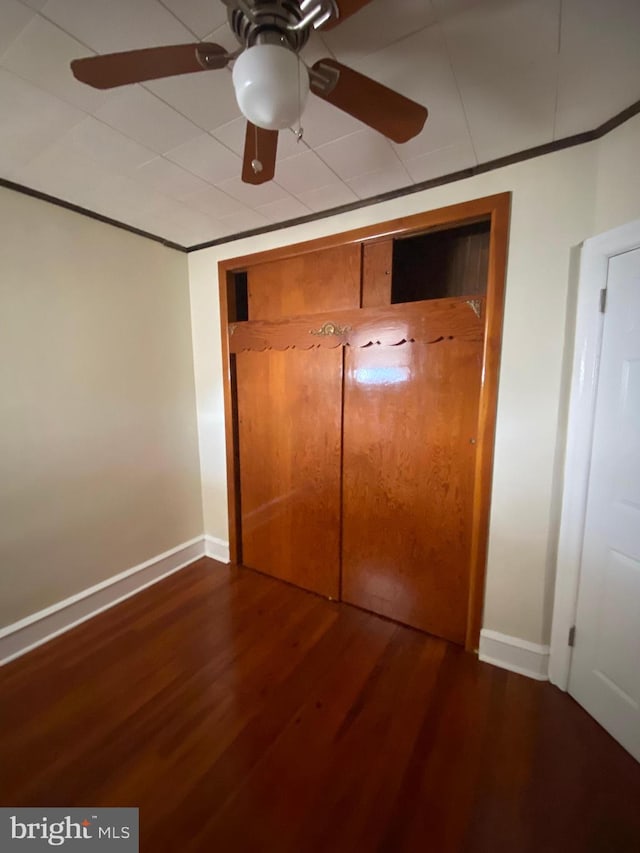 unfurnished bedroom with a closet, wood-type flooring, and ceiling fan