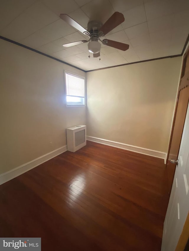 spare room featuring dark wood-type flooring and ceiling fan