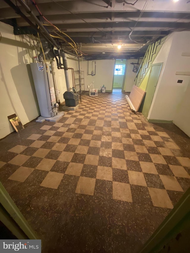 basement with tile patterned flooring and gas water heater