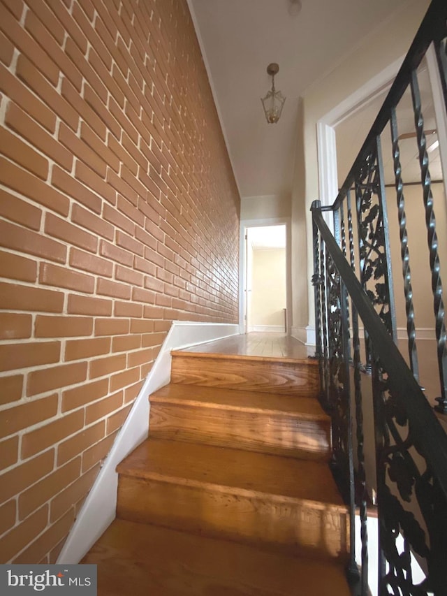 stairs featuring brick wall