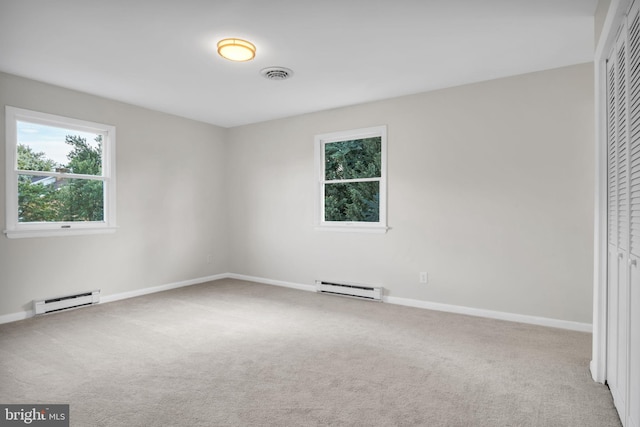 unfurnished bedroom featuring baseboard heating, carpet flooring, and a closet