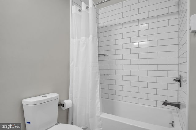 bathroom featuring toilet and shower / tub combo with curtain