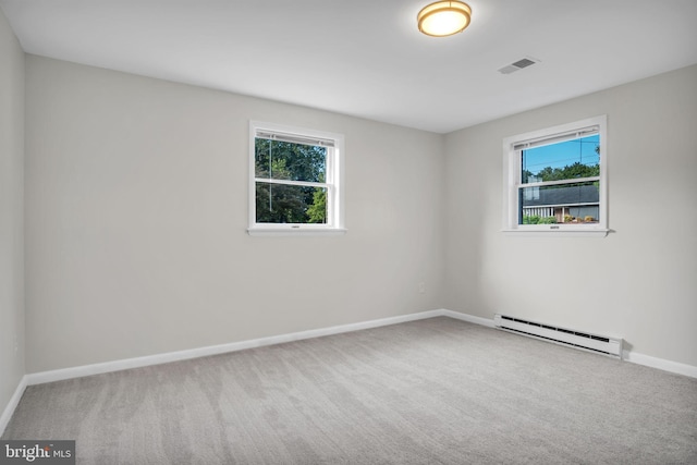 carpeted empty room with baseboard heating and a wealth of natural light