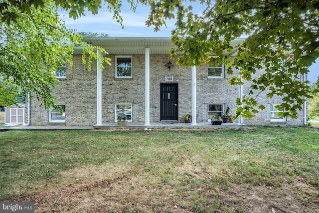 bi-level home featuring a front yard and a storage unit