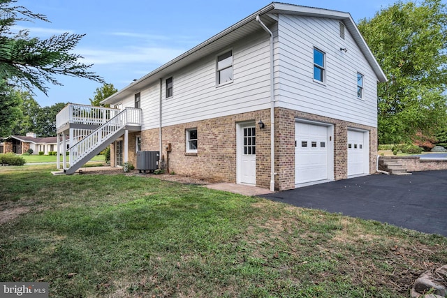 view of side of home with a yard, a garage, central AC, and a deck