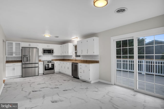 kitchen featuring white cabinetry, stainless steel appliances, and decorative backsplash